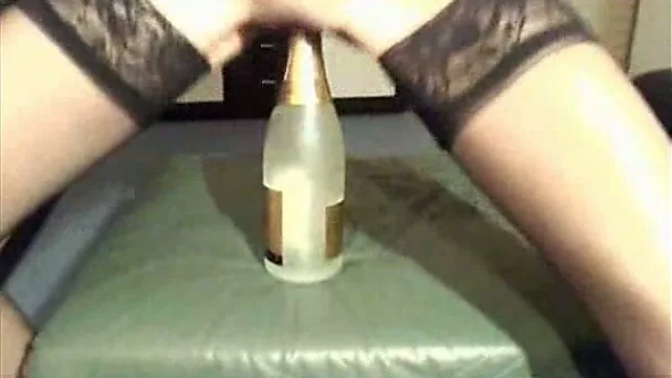 Skinny brunette wifey in stockings shoving a bottle in her puss
