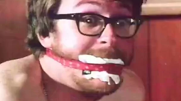 That man has gag in his mouth and his hands tied on his back