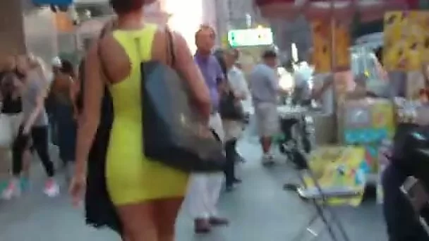 Slim beauty in tight yellow dress walks it out outdoors