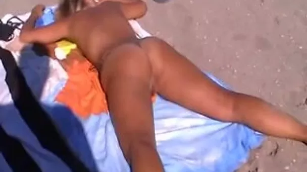 Blonde milf lady on the nudist beach with her legs wide open
