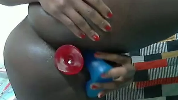 Ebony slut plugs both holes in front of the camera