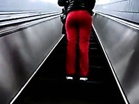 This slim chick on an escalator looks very tempting in tight red pants
