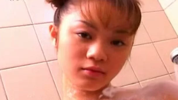 Horny Japanese coed with perky tits lathers her body with soap seductively