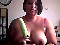 Thick and busty brunette strumpet on webcam plays with a cucumber