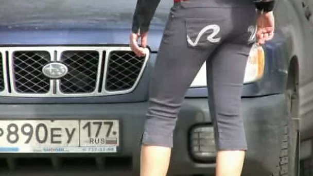 Juicy Russian brunette lady hides behind the car and pisses