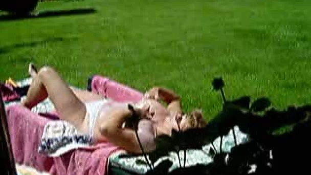 Chubby mature wife of my neighbor takes a sunbath in the backyard