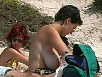 Hidden cam clip with a mom rubbing her big tits at a nude beach