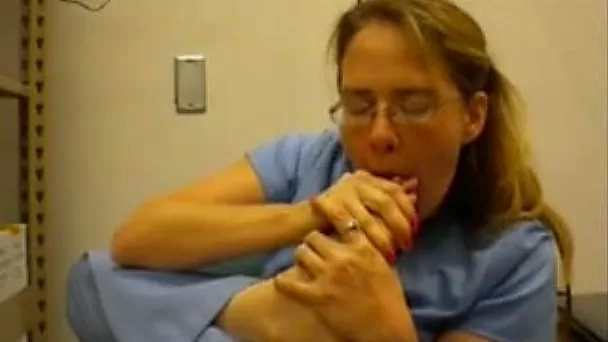 Nerdy woman in nurse uniform licks her toes in front of a webcam