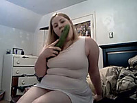 Delightful blonde babe with a big cucumber tries to eat it