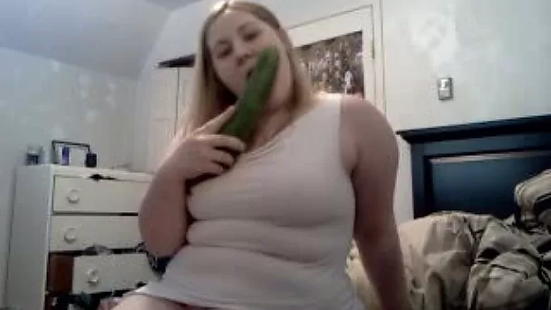 Delightful blonde babe with a big cucumber tries to eat it