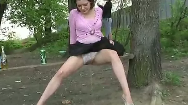 Beautiful brunette sits on the bench and pisses right there