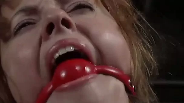 Busty redhead slut gets bound to a chair in BDSM clip