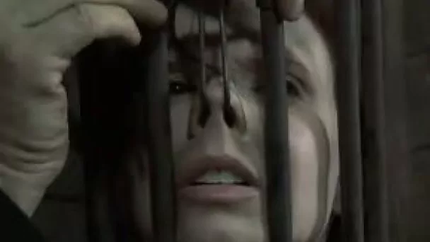 Brunette chick wearing head cage gets her snatch and mouth drilled with a dildo