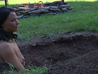 Brunette leashed milf slut buried in the ground outdoors