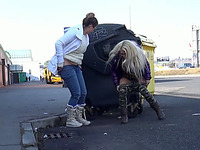 Two lewd amateur skanks hide behind a trash bin to pee