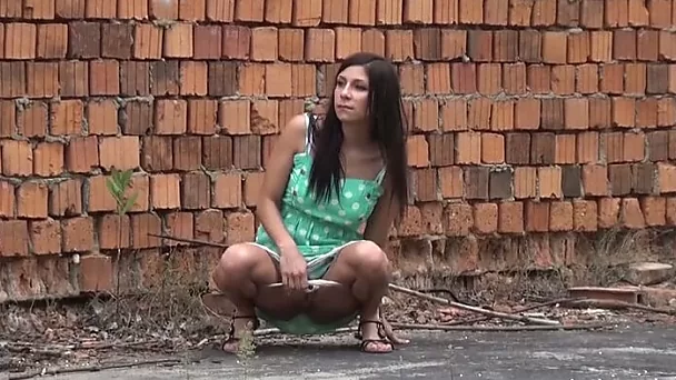Pretty shameless amateur brunette pulls up her green dress to pee outdoors