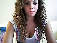 Curly haired beauty on webcam uses a double headed toy
