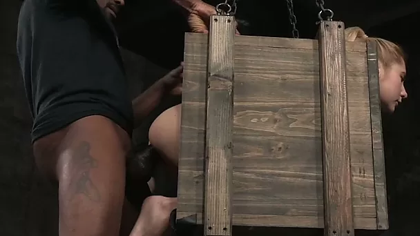 Cute blonde beauty in the box fucked by two horny masters