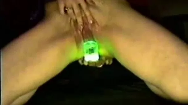 Slender white lady uses glowing stick for masturbation
