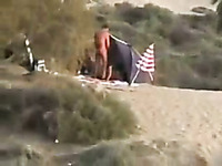 Two perverted guys pissing on a woman on a nudist beach