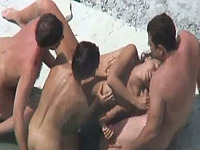 Two local sluts on the beach with two men having foursome