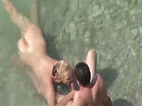 Blondie on the nude beach gives blowjob to her man