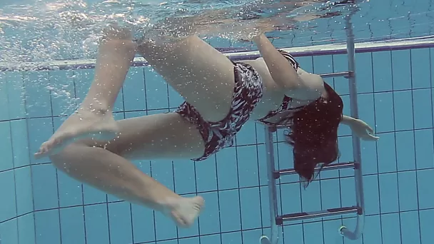 Beautiful brunette white girl under water in the pool