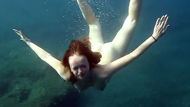 Cute redhead teen babe in the open blue sea underwater
