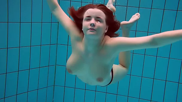 Busty redhead seductress from Russia exposes her pussy