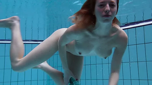 Busty redhead European babe spreads her legs under water