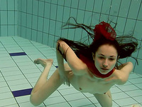 Adorable brunette teenie underwater flashes her shaved cooter