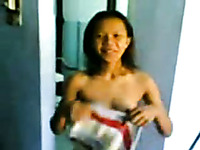 Petite bodied Malay girl smoking cigarette in a hotel room