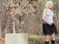 Busty and curvaceous blondie in the park pisses behind the concrete