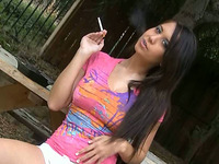 Brunette cute teen chick chilling and smoking in the park