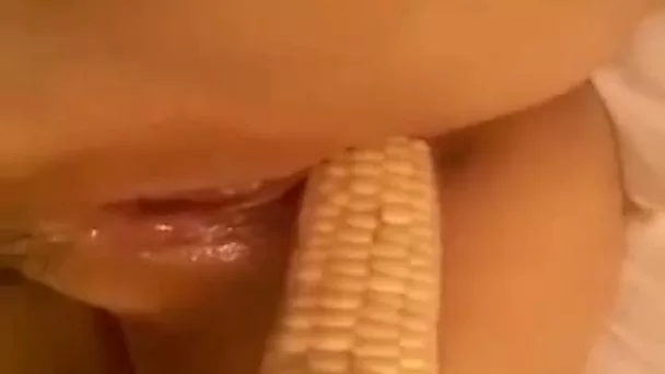 Nice closeup of a wild bitch petting her bald cunt with a corn