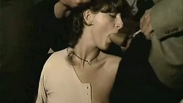 Hot and submissive brunette feeding on two cocks outside