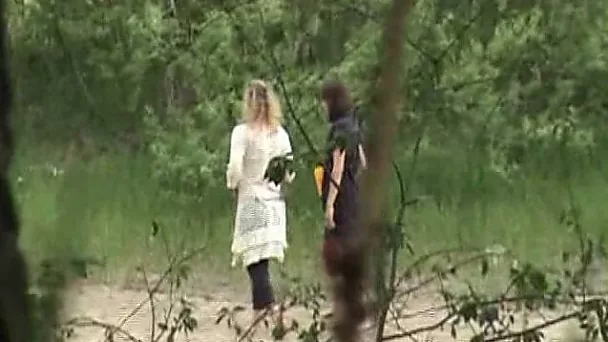 Cute young blonde girl walks in the high grass to piss