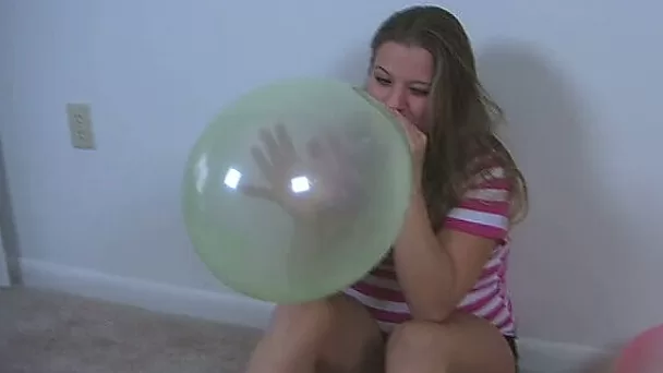 Straight haired a bit plump brunette in T-shirt plays with balloons