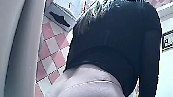 Hot brunette young chick in black panties pisses in the toilet
