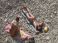 Adorable bronze skin shiny brunette sunbathing on the beach nude