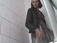 Brunette hot woman in the public restroom recorded from behind