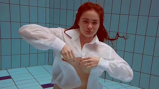 Sizzling hot redhead teen takes off white shirt underwater