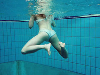 Redhead slender teen chick in sexy bikini dives in the pool