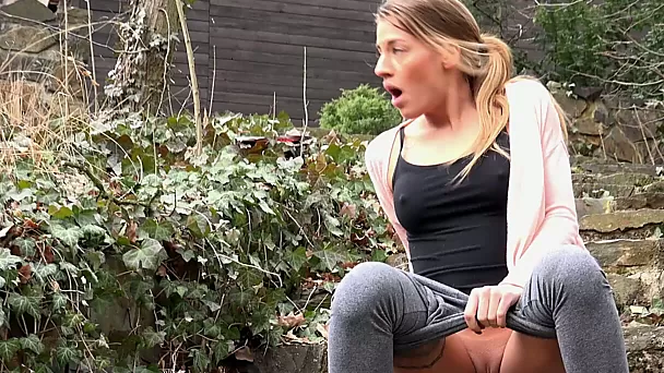 Nice sporty slender girl pulls down her grey yoga pants and pisses