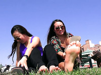 Slutty girls flash their cute feet while sitting on the lawn