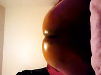 Lustful ebony chick oils up her bubbled ass and fucks it