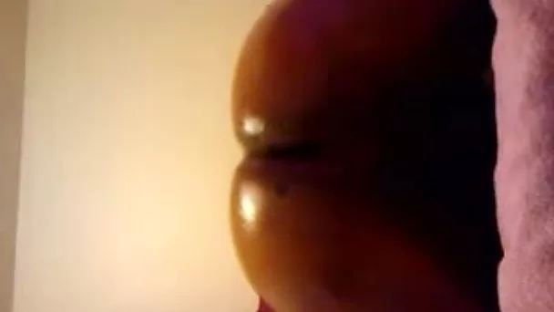 Lustful ebony chick oils up her bubbled ass and fucks it
