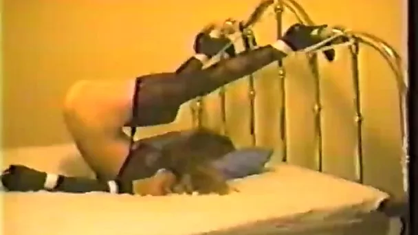 With her legs tied to the bed this blonde's ass is just begging to get spanked