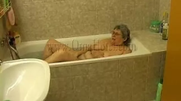 Fat old whore masturbates in the bath tub with anal beads