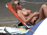 Spying on sexy blonde MILFs while they sunbathe on a beach